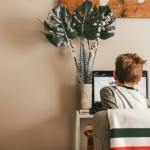 Young boy studying at home on a laptop for online learning in a cozy room.